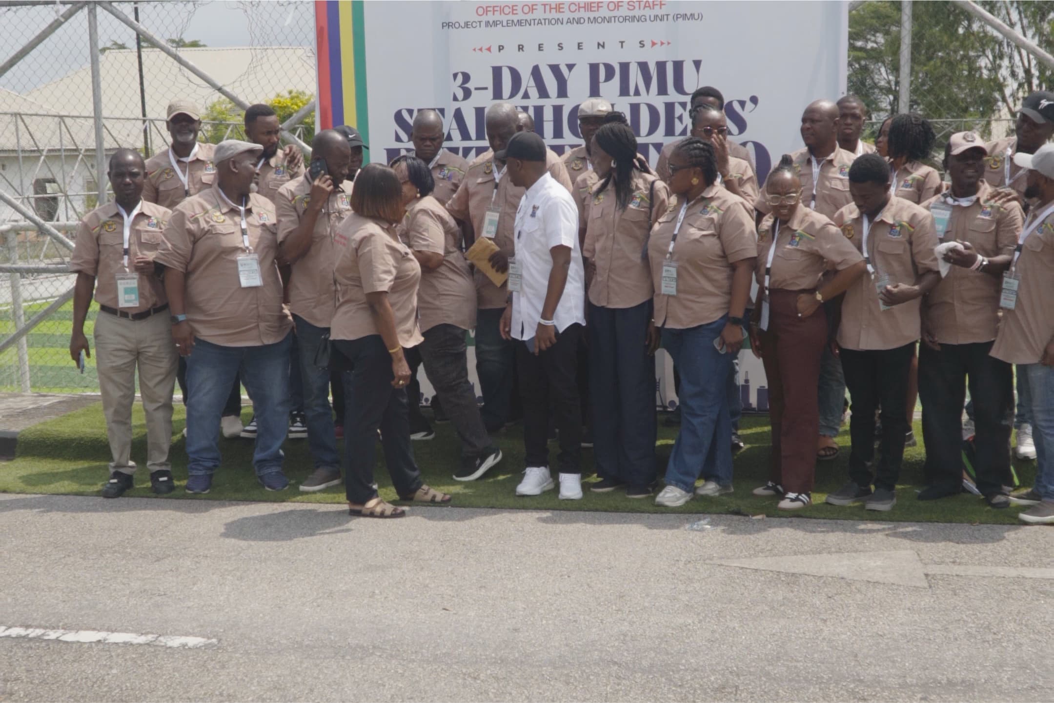 A large group gathered outdoors in front of an event banner